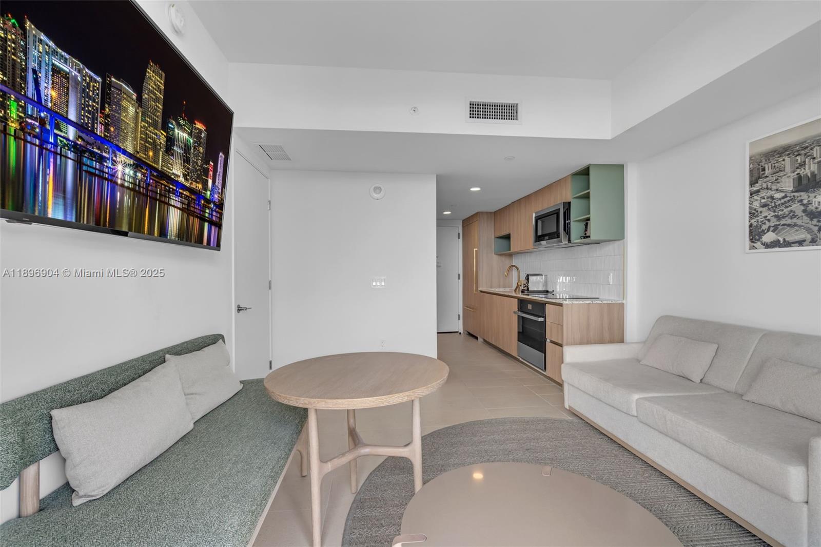 This studio apartment features a kitchenette, a dining table, and two sofas — 159 NE 6th St # 4514, Miami FL 33132, MIAMI, FL