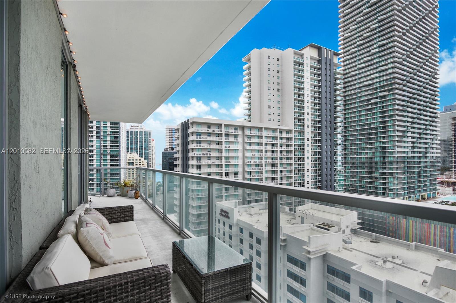 A balcony with outdoor furniture overlooks a dense urban skyline of high-rise apartment buildings — 79 SW 12th St, Miami FL 33130, MIAMI, FL