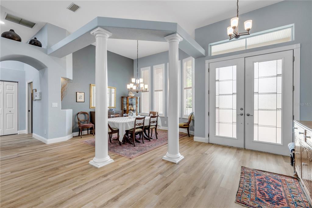A dining area features white columns, light wood-look flooring, and a double-door entryway — 6095 SUMMERLAKE DRIVE, PORT ORANGE, FL