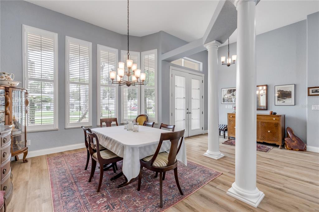 A dining room features a white-clothed table, a chandelier, large windows, and two white columns — 6095 SUMMERLAKE DRIVE, PORT ORANGE, FL