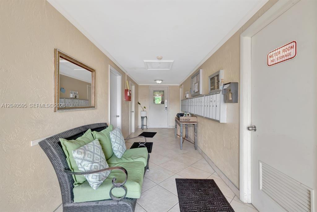 A hallway features a wicker loveseat, a row of mailboxes, and a meter room door — FORT LAUDERDALE, FL