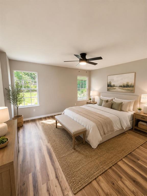 A bedroom features light wood floors, a neutral color palette, and a large area rug — 3604 NW 51ST TERRACE, GAINESVILLE, FL