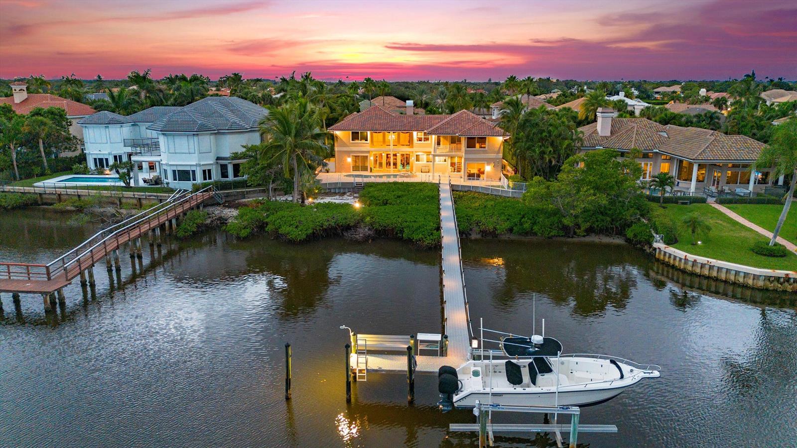 An aerial view of a waterfront house with a long dock and a boat — 3164 Casseekey Island Road, Jupiter FL 33477, JUPITER, FL