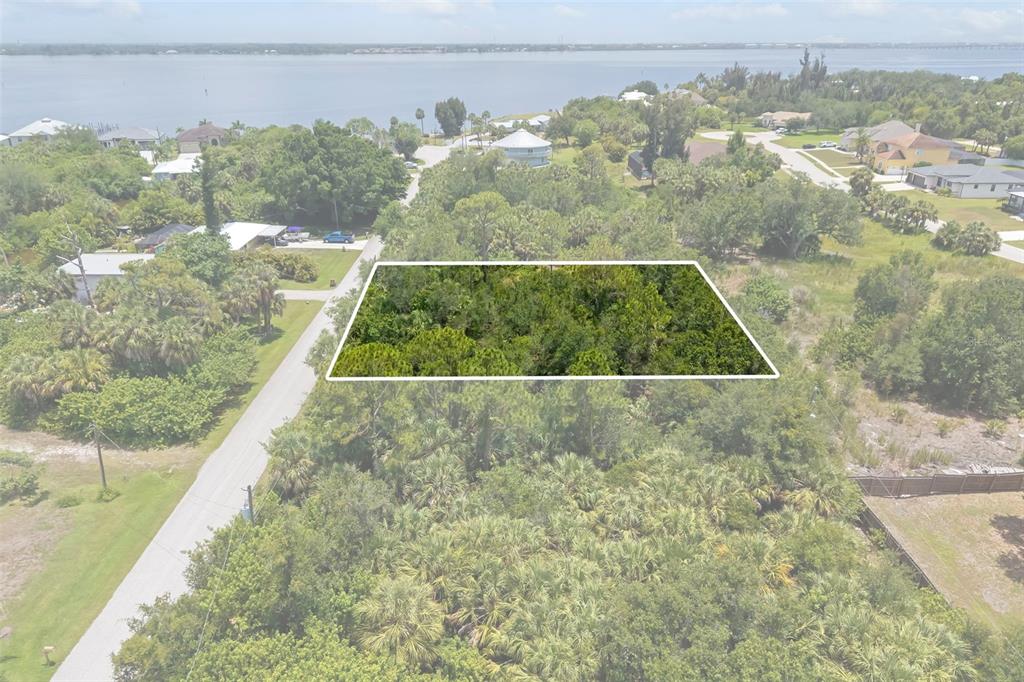 An aerial view shows a rectangular, wooded vacant lot outlined in white near a waterfront — 186 NORTHSHORE TERRACE, PUNTA GORDA, FL