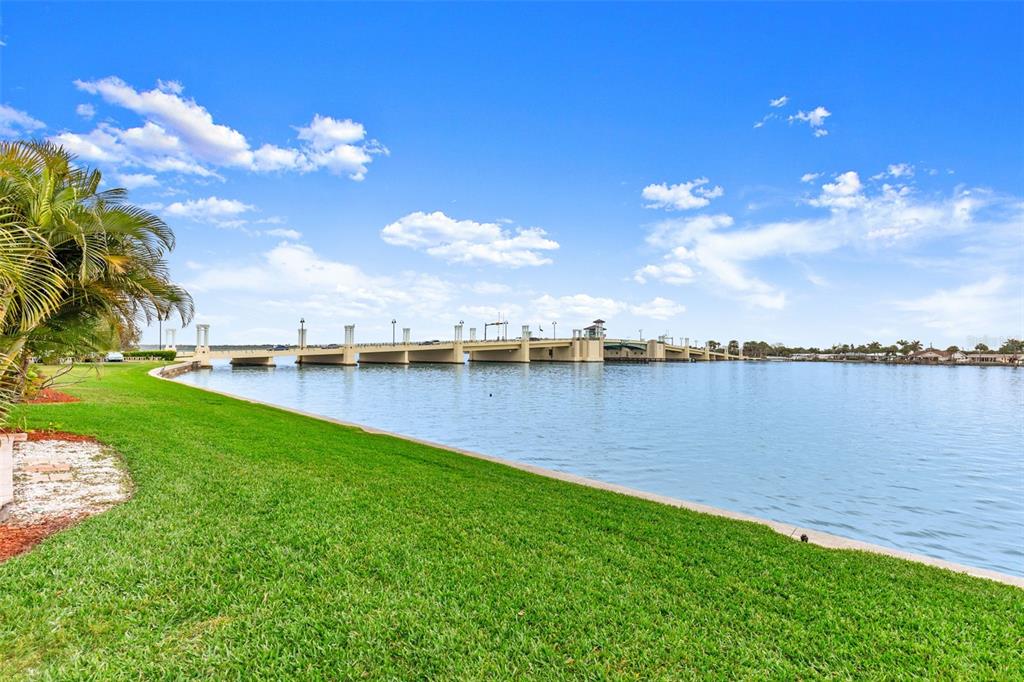 A grassy lawn overlooks a body of water with a bridge in the distance — 500 TREASURE ISLAND CAUSEWAY UNIT 205, TREASURE ISLAND, FL