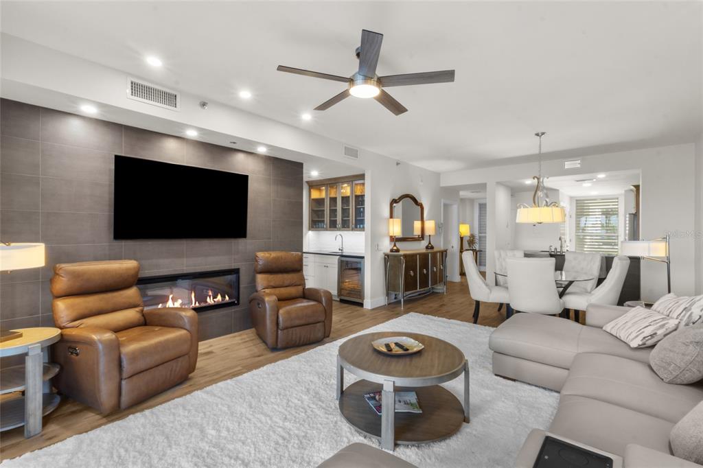 A living room features a tiled fireplace wall, leather recliners, and a white area rug — 615 DREAM ISLAND PLACE UNIT 105, LONGBOAT KEY, FL