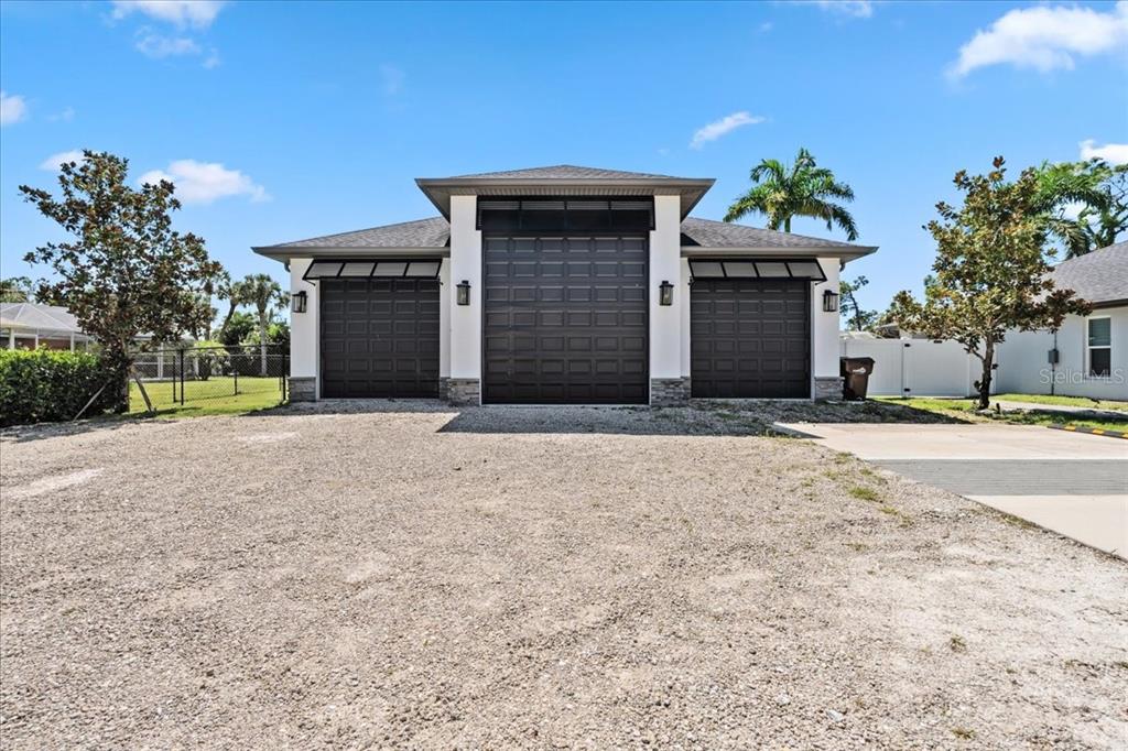 A detached three-car garage with a white stucco exterior and dark brown doors — 2415 W PRICE BOULEVARD, NORTH PORT, FL