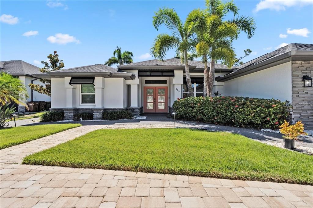 A single-story house with a white exterior, stone accents, and a double front door — 2415 W PRICE BOULEVARD, NORTH PORT, FL