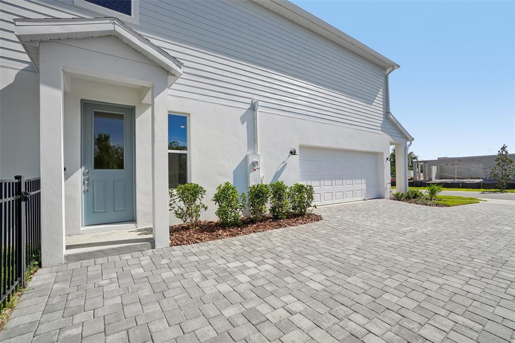 A light blue front door and a white garage door face a paved driveway — 610 SILVER STREAM COURT, BRANDON, FL