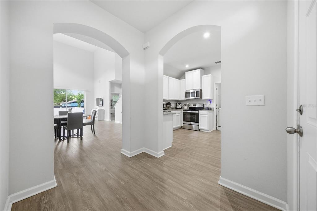 A view from a hallway looking into a dining area and a white kitchen — 2130 LACEFLOWER DRIVE, BRANDON, FL