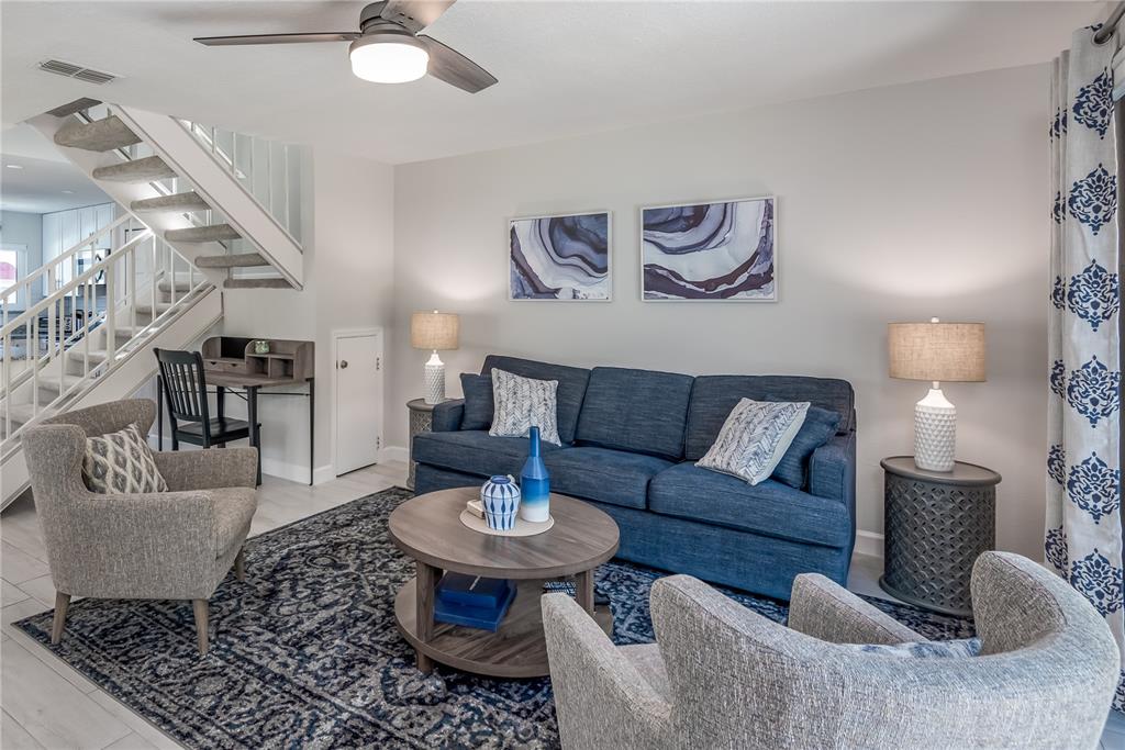 A living room features a blue sofa, two gray armchairs, and a staircase — 218 SEAPORT BOULEVARD UNIT T48, CAPE CANAVERAL, FL
