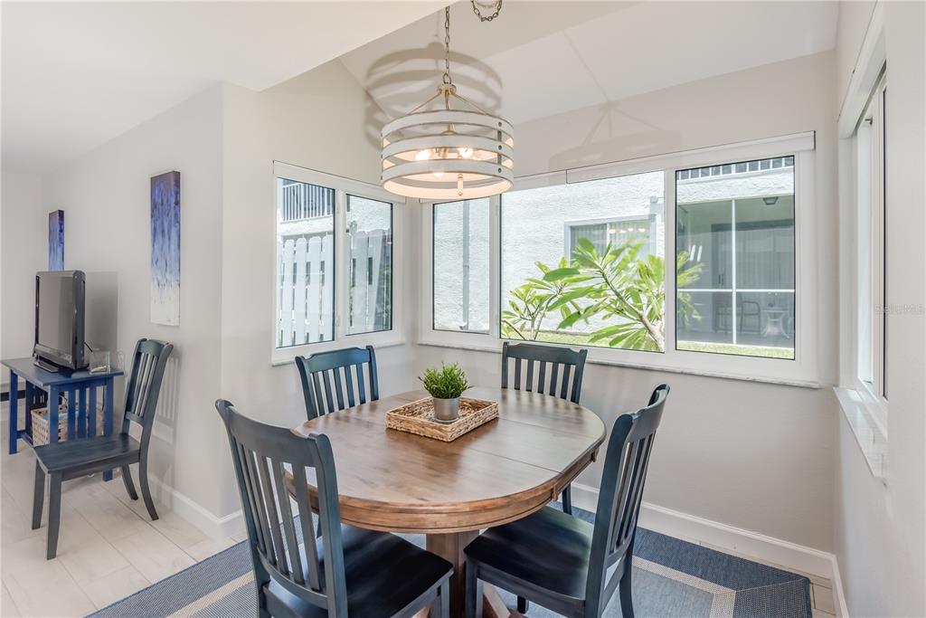 A dining area features a round wooden table, four dark chairs, and a drum pendant light — 218 SEAPORT BOULEVARD UNIT T48, CAPE CANAVERAL, FL