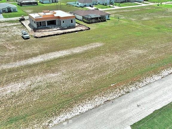 An aerial view shows a house under construction on a large, grassy residential lot — 1037 NW 37TH PLACE, CAPE CORAL, FL