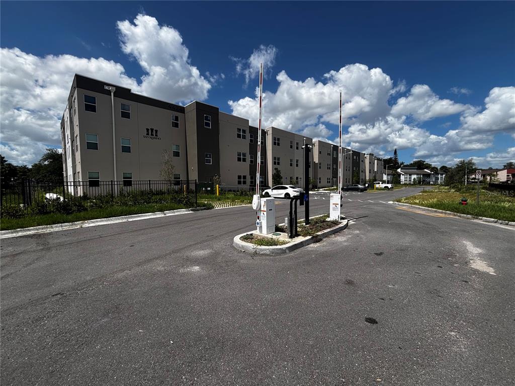 An exterior view of an apartment complex entrance with a gated security arm — 4424 S TEXAS AVENUE UNIT 1-204, ORLANDO, FL