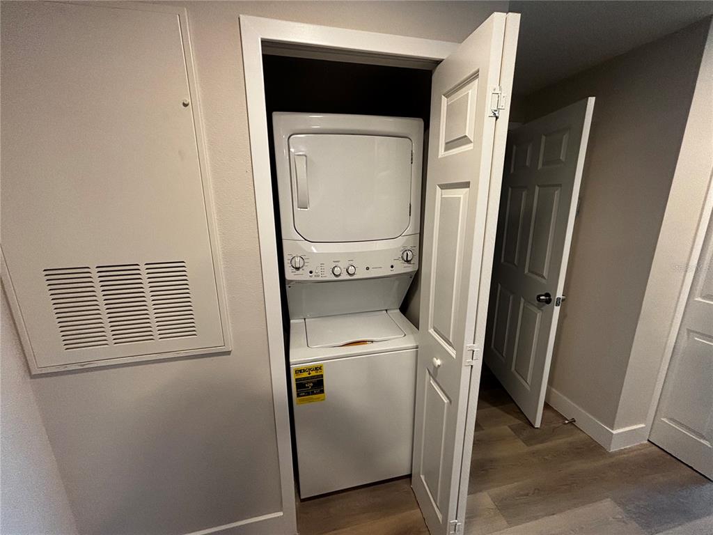 A stacked washer and dryer unit is located inside a small closet in a room — 4424 S TEXAS AVENUE UNIT 1-204, ORLANDO, FL