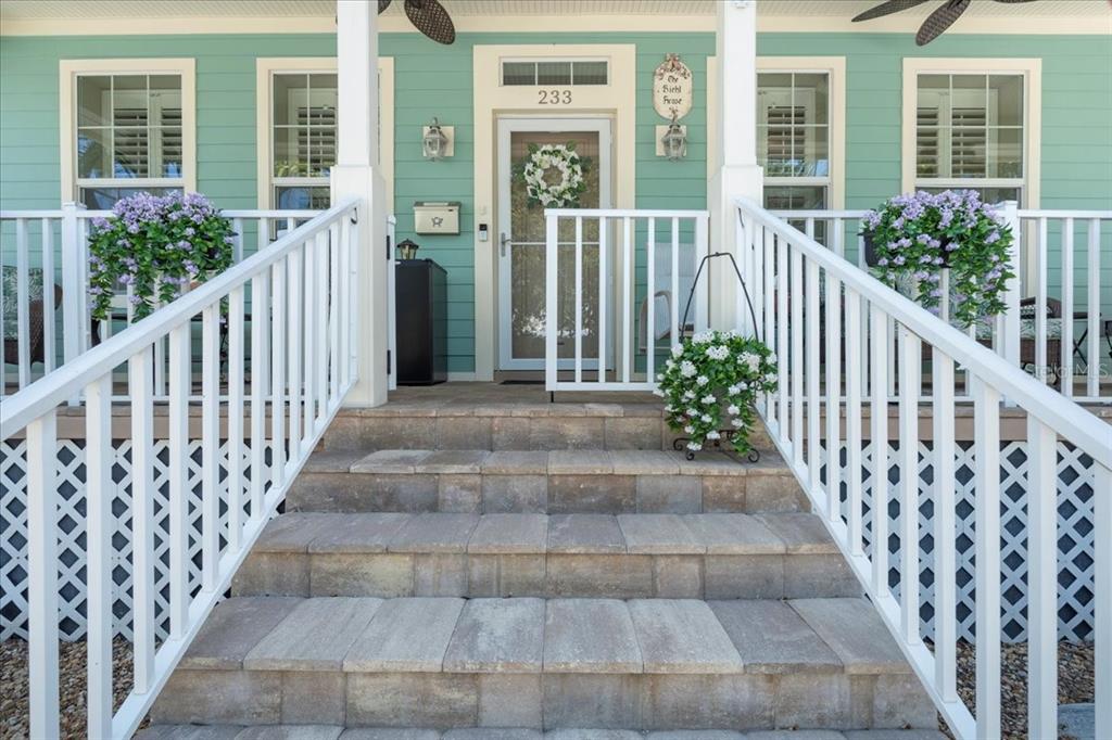 A light blue house with a two-car garage, front porch, and palm trees in front — 233 DURRANCE STREET, PUNTA GORDA, FL