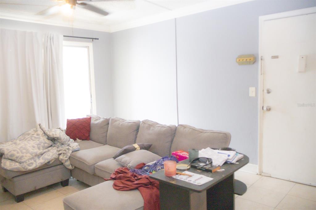 A living room features a gray sectional sofa, a small side table, and tiled flooring — 924 LAKE DESTINY ROAD UNIT D, ALTAMONTE SPRINGS, FL