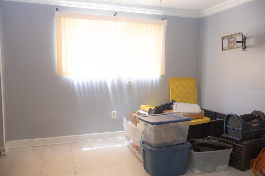 A room with light blue walls, tile flooring, a window with vertical blinds, and storage bins — 924 LAKE DESTINY ROAD UNIT D, ALTAMONTE SPRINGS, FL