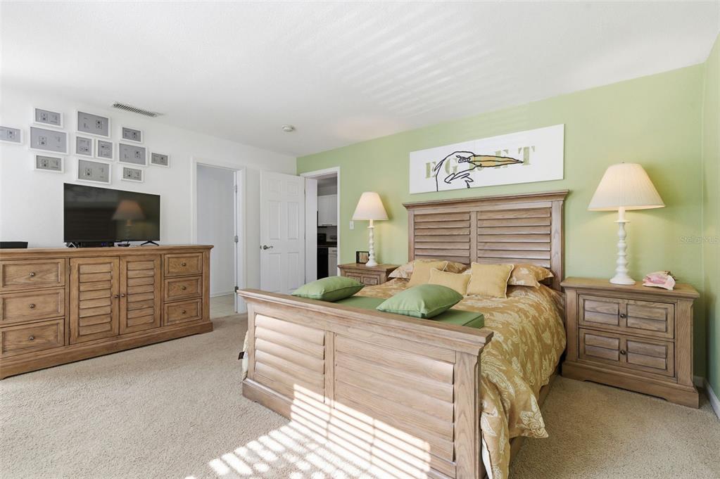 A bedroom features a wooden bed frame, matching dresser, and a light green accent wall — 5005 COQUINA KEY DRIVE SE UNIT E, ST PETERSBURG, FL