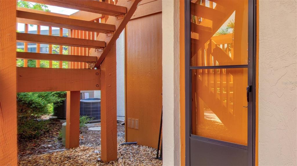 A view of an outdoor staircase, a screen door, and an air conditioning unit — 1700 COVE II PLACE UNIT 310, SARASOTA, FL