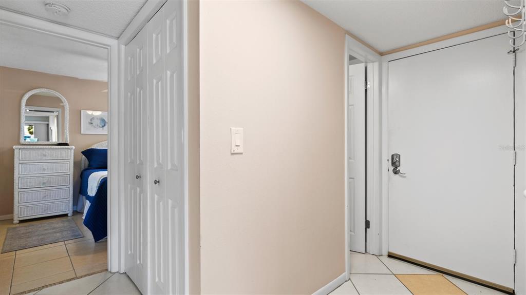 A hallway features white doors, a light switch, and a view into a bedroom — 1700 COVE II PLACE UNIT 310, SARASOTA, FL