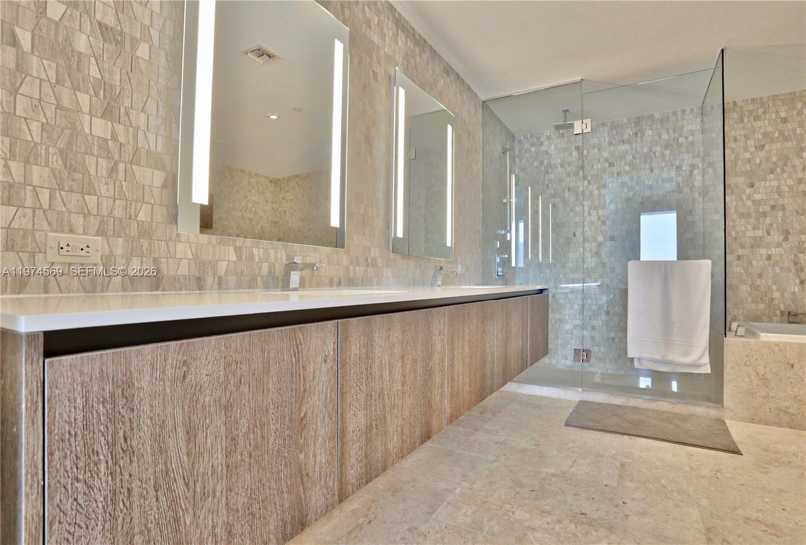 A modern bathroom features a floating wood vanity, dual mirrors, and a glass-enclosed shower — 88 SW 7th St # 3805, Miami FL 33130, MIAMI, FL