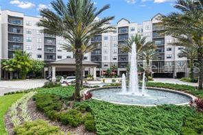 A multi-story apartment building features a large circular fountain in the landscaped front courtyard — 14501 GROVE RESORT AVE UNIT 3621, WINTER GARDEN, FL