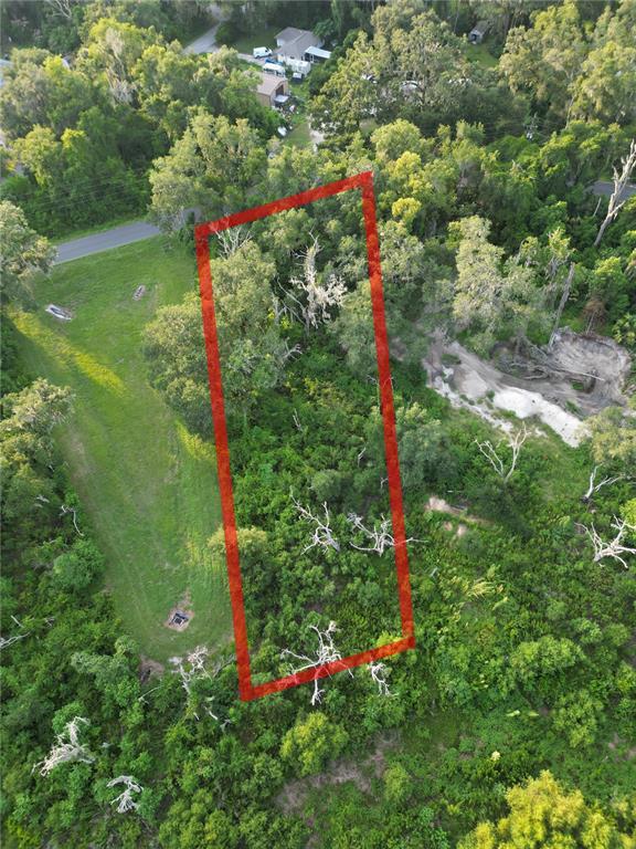 An aerial view shows a rectangular red outline marking a wooded lot next to a road — 3418 E PERRY STREET, INVERNESS, FL