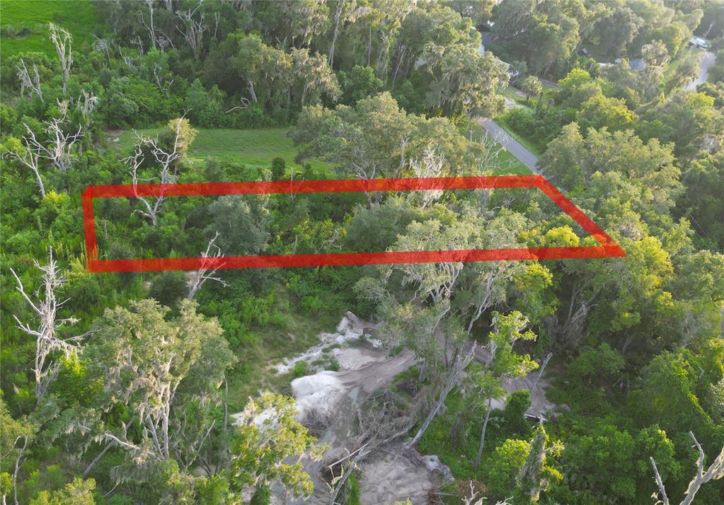 An aerial view shows a rectangular red outline highlighting a wooded lot with sandy ground — 3418 E PERRY STREET, INVERNESS, FL