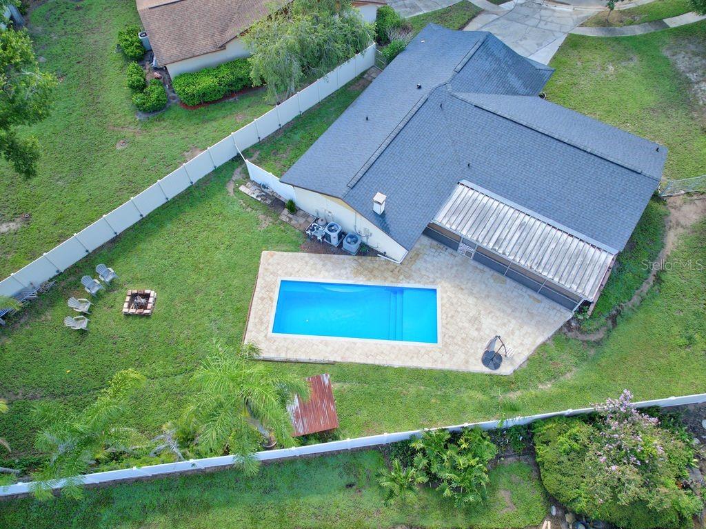 An aerial view shows a house with a swimming pool, patio, and fenced backyard — 3110 CLOVEWOOD PLACE, SEFFNER, FL