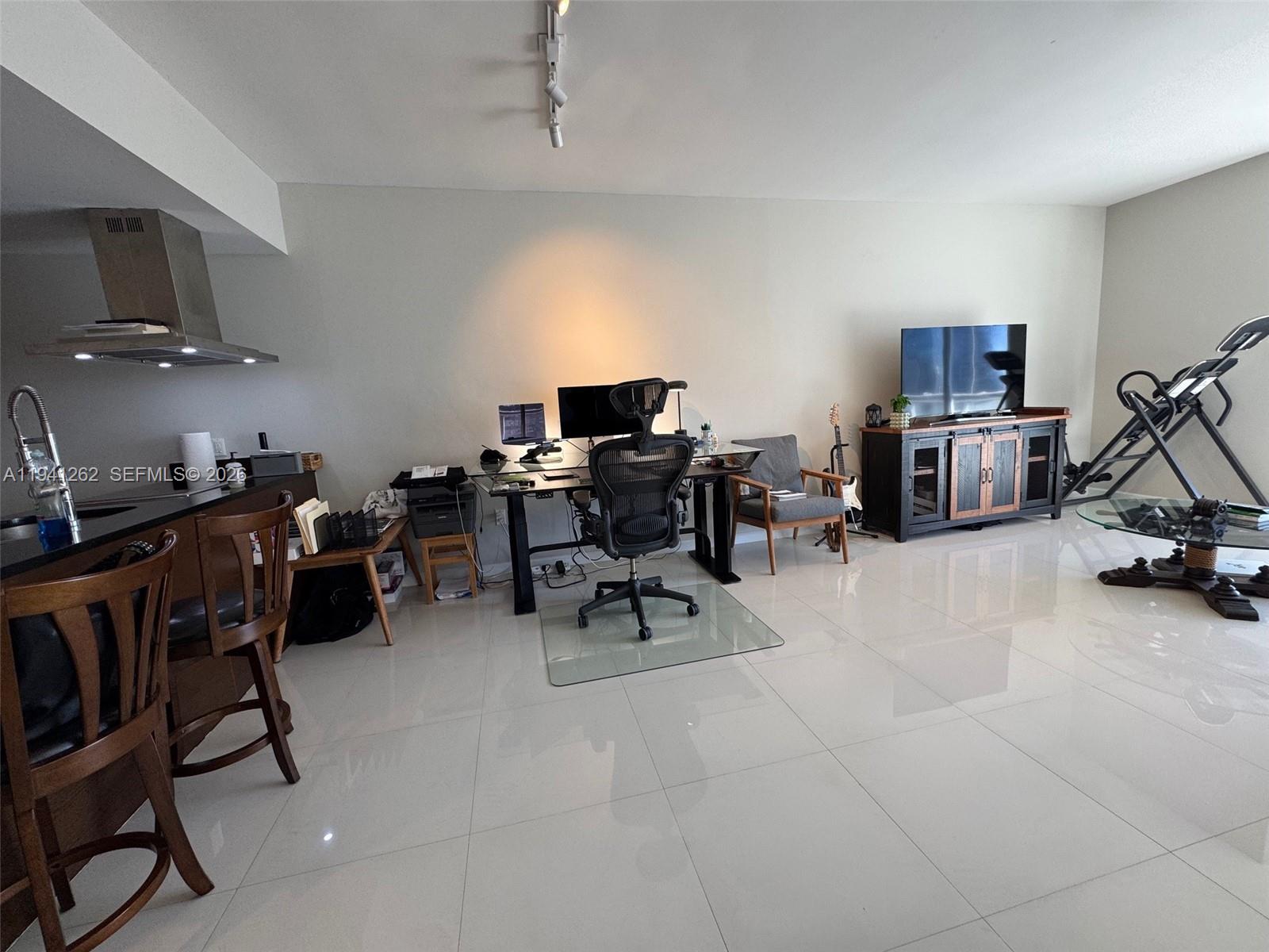 A spacious room features a kitchen island, a home office area, and a television console — 495 Brickell Ave # 3507, Miami FL 33131, MIAMI, FL