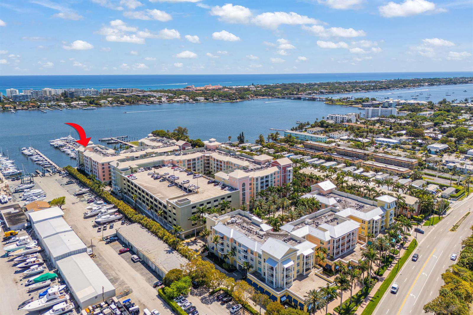An aerial view shows a multi-story waterfront apartment complex with a marina and parking garage — 806 E Windward Way # 403, Lantana FL 33462, LANTANA, FL