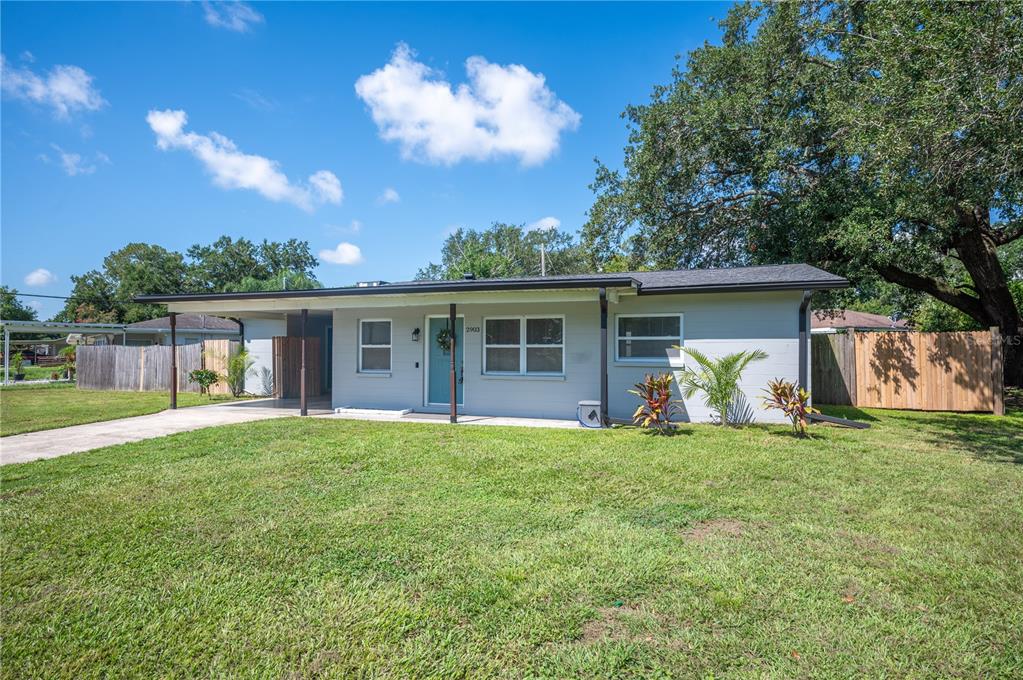 A single-story house with a gray exterior, a light blue front door, and a lawn — 2903 STANHOPE AVENUE, LAKELAND, FL