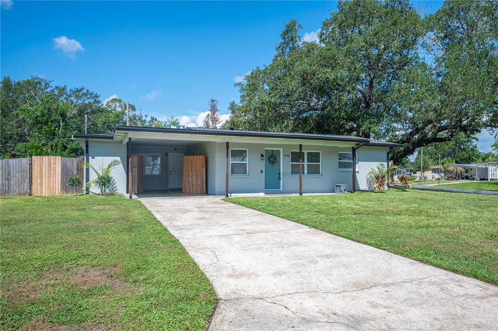 A single-story house with a light gray exterior, a carport, and a concrete driveway — 2903 STANHOPE AVENUE, LAKELAND, FL