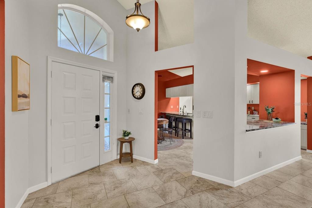 A tiled entryway features a white front door, a high ceiling, and an arched window — 2023 PRESTANCIA LANE, SUN CITY CENTER, FL