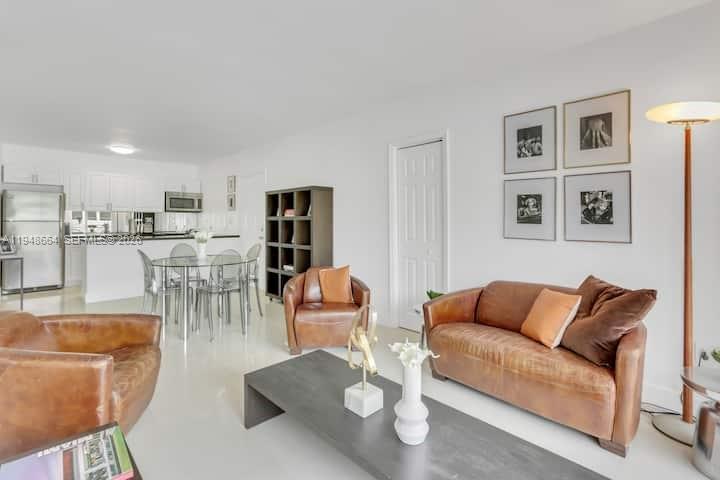 A living room with leather furniture, a dark coffee table, and an open-concept kitchen — 290 Sunrise # 206, Key Biscayne FL 33149, KEY BISCAYNE, FL