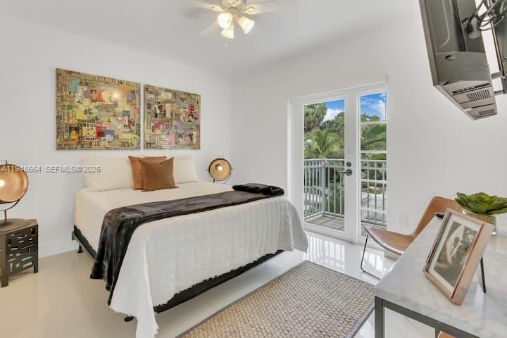 A bedroom features a bed, a desk, a balcony door, and two large framed artworks — 290 Sunrise # 206, Key Biscayne FL 33149, KEY BISCAYNE, FL
