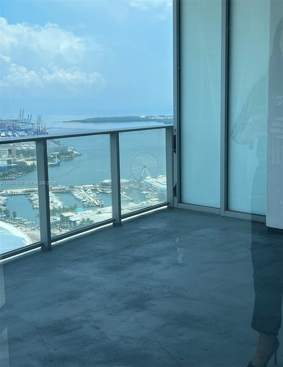 A balcony with a glass railing overlooks a harbor, a marina, and a Ferris wheel — 851 NE 1st Ave # 3803, Miami FL 33132, MIAMI, FL