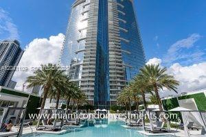 A tall glass skyscraper rises above a swimming pool surrounded by palm trees and cabanas — 851 NE 1st Ave # 3803, Miami FL 33132, MIAMI, FL