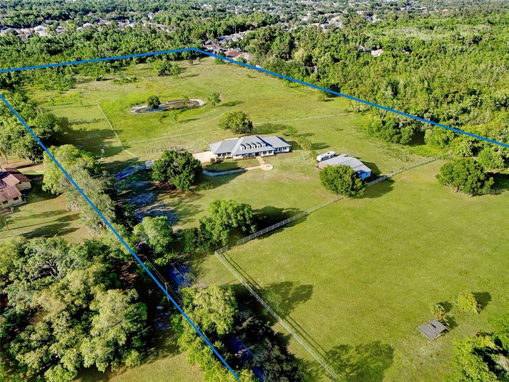 An aerial view shows a house and outbuilding on a large, fenced rural property — 5750 OAK HOLLOW LANE, OVIEDO, FL