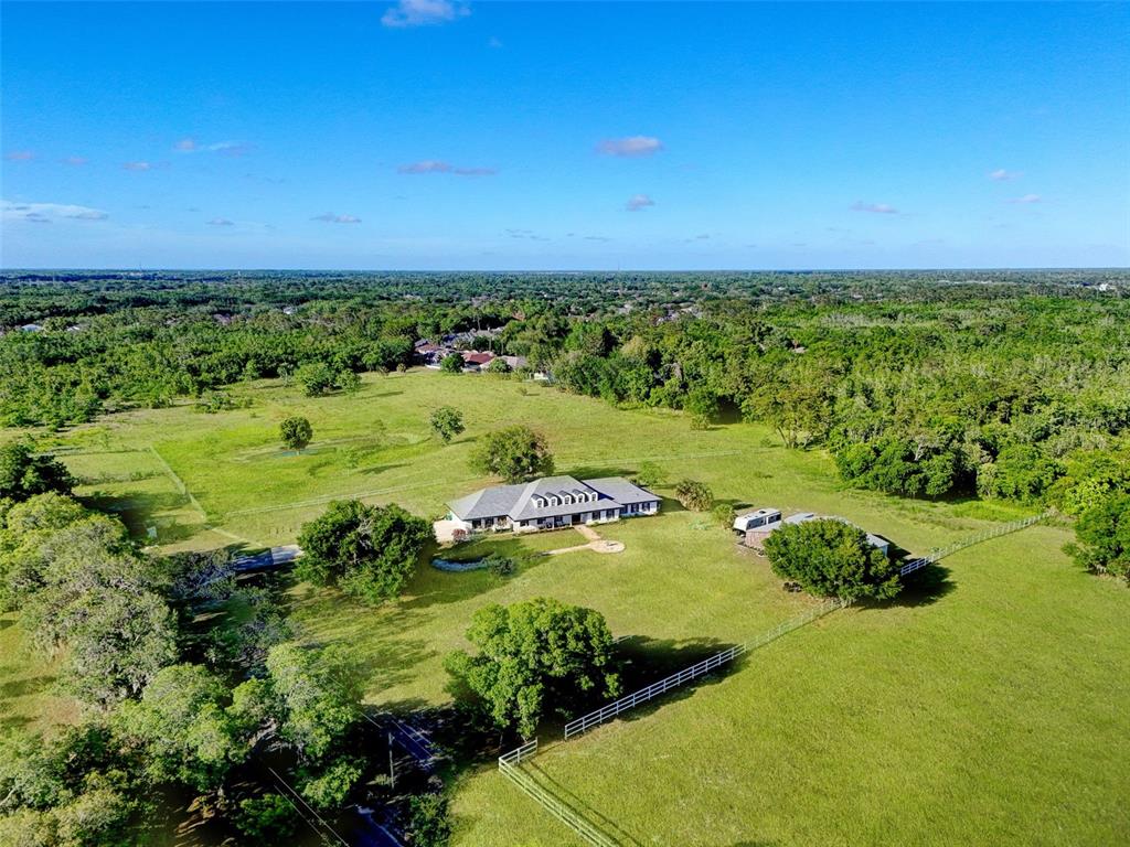 An aerial view shows a single-story house with a white exterior on a large lot — 5750 OAK HOLLOW LANE, OVIEDO, FL