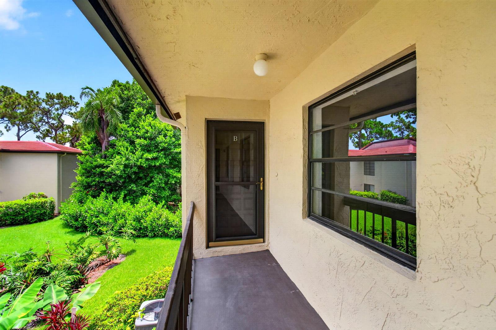 An exterior view of a balcony with a screen door and a large window — 8460 Casa Del Lago, Boca Raton FL 33433, BOCA RATON, FL