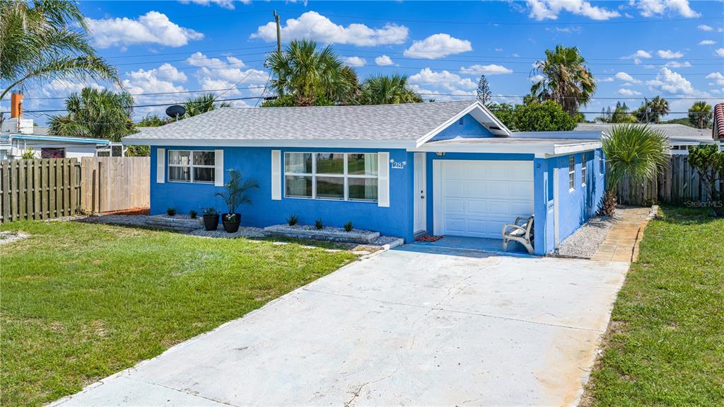 A blue single-story house with a white garage door and a concrete driveway — 28 BEECHWOOD DRIVE, ORMOND BEACH, FL
