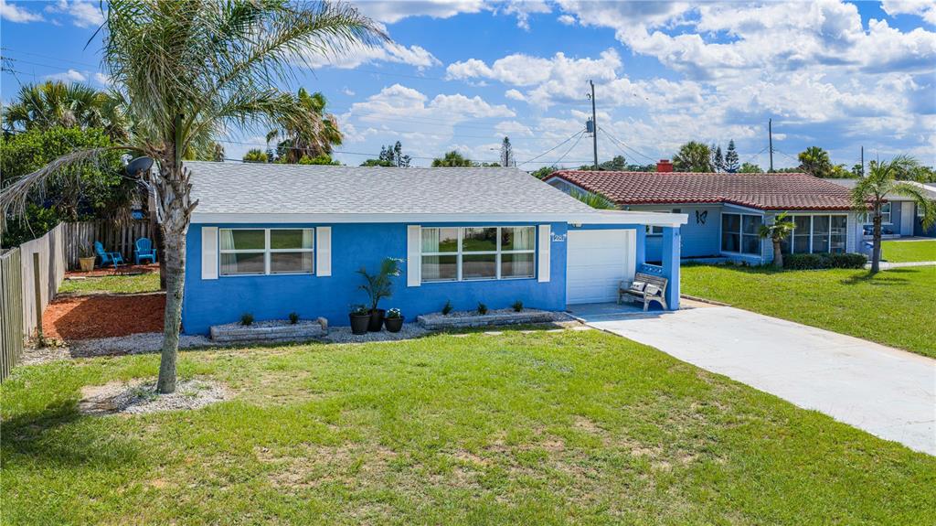 A bright blue single-story house with a white roof, garage, and a front lawn — 28 BEECHWOOD DRIVE, ORMOND BEACH, FL