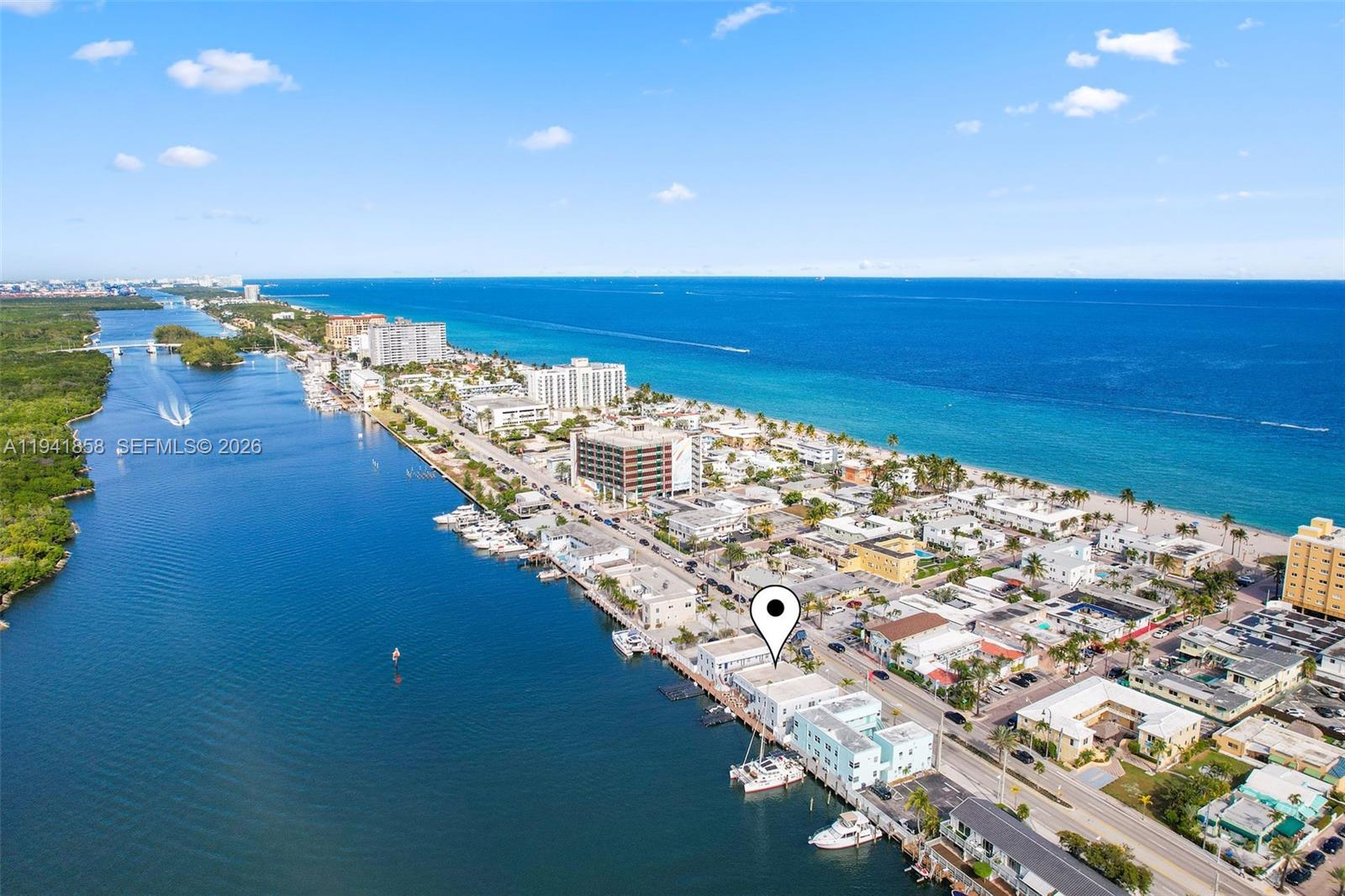 An aerial view shows a coastal neighborhood with a waterway, beach, and residential buildings — 1908 N Ocean Dr, Hollywood FL 33019, HOLLYWOOD, FL