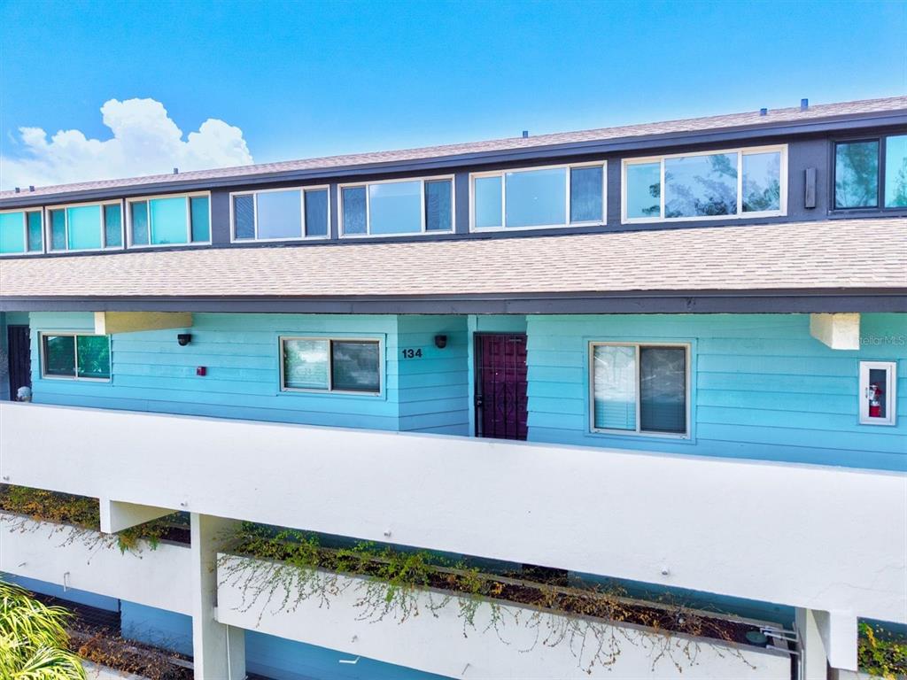 An exterior view of a light blue two-story building with a white balcony and windows — 9604 CORTEZ ROAD W UNIT 134, BRADENTON, FL