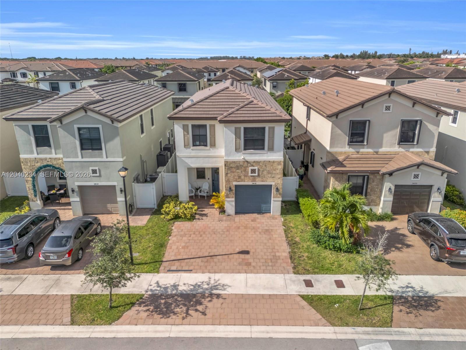 An aerial view shows three two-story suburban houses with tiled roofs and paved driveways — 3416 W 109th Pl, Hialeah FL 33018, HIALEAH, FL