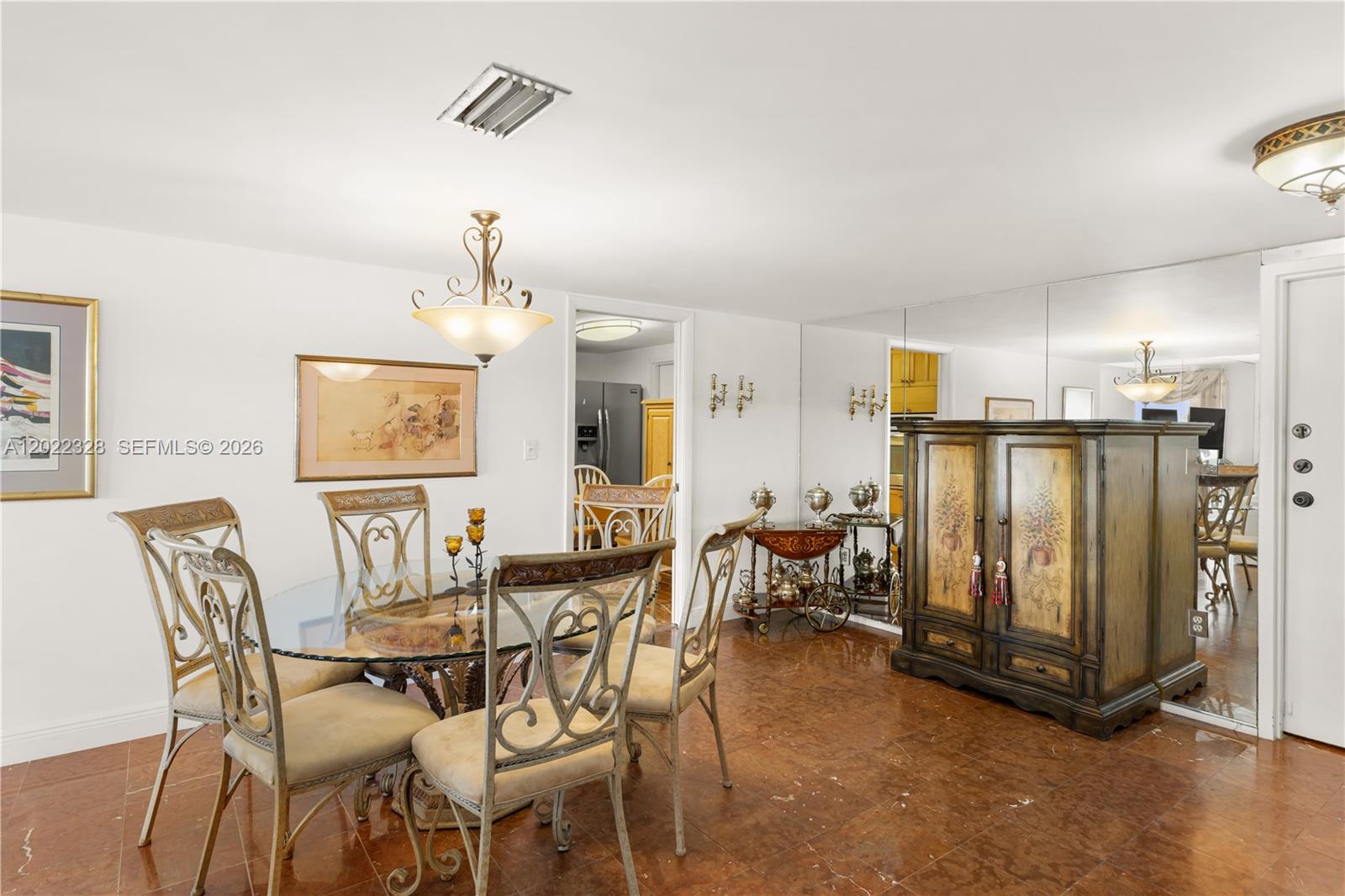 A dining room features a glass table, metal chairs, a decorative cabinet, and mirrored walls — 210 Sea View Dr # 611, Key Biscayne FL 33149, KEY BISCAYNE, FL