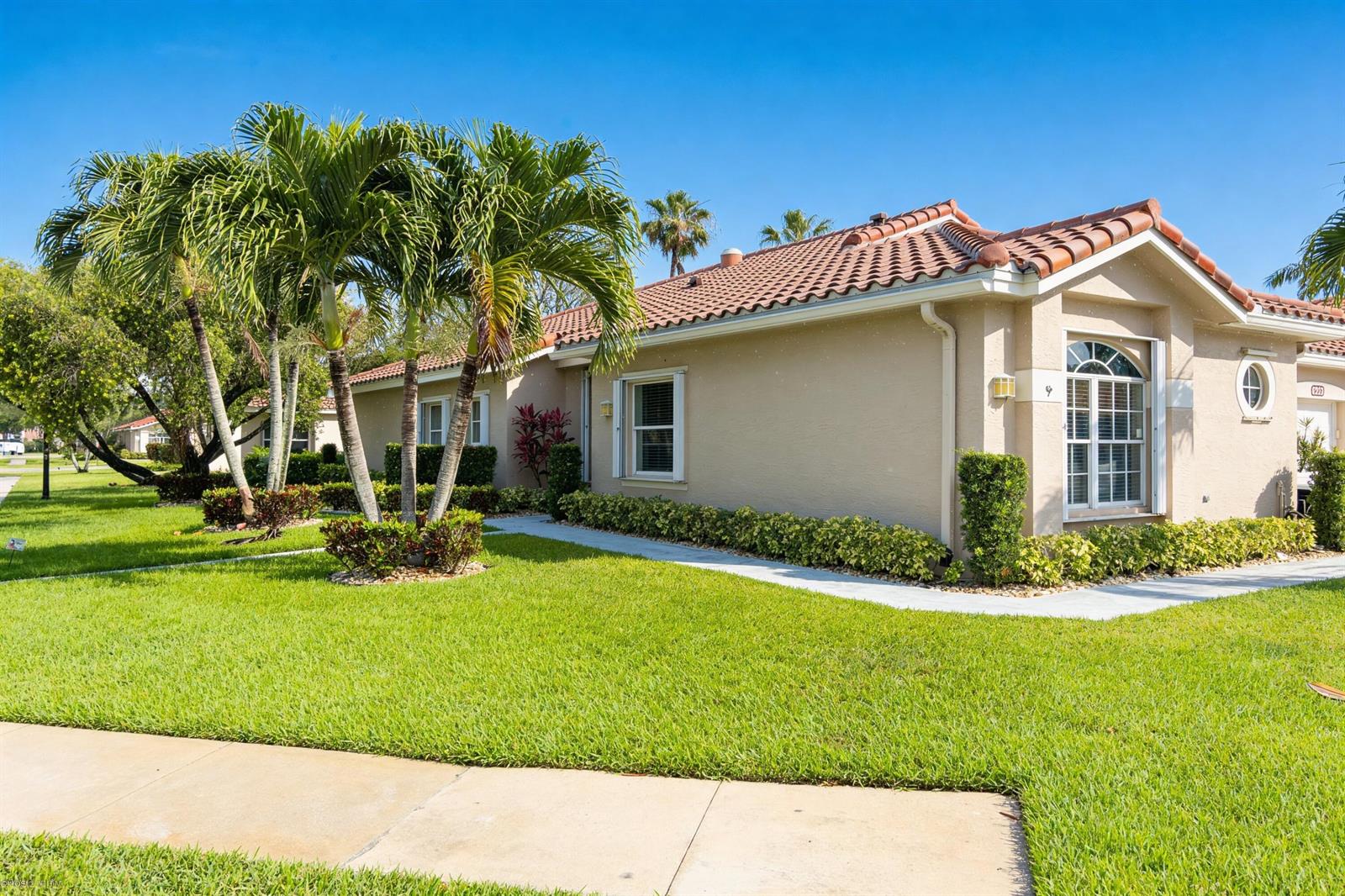 A tan single-story house with a tiled roof, palm trees, and a manicured lawn — 6419 Long Key Lane, Boynton Beach FL 33472, BOYNTON BEACH, FL
