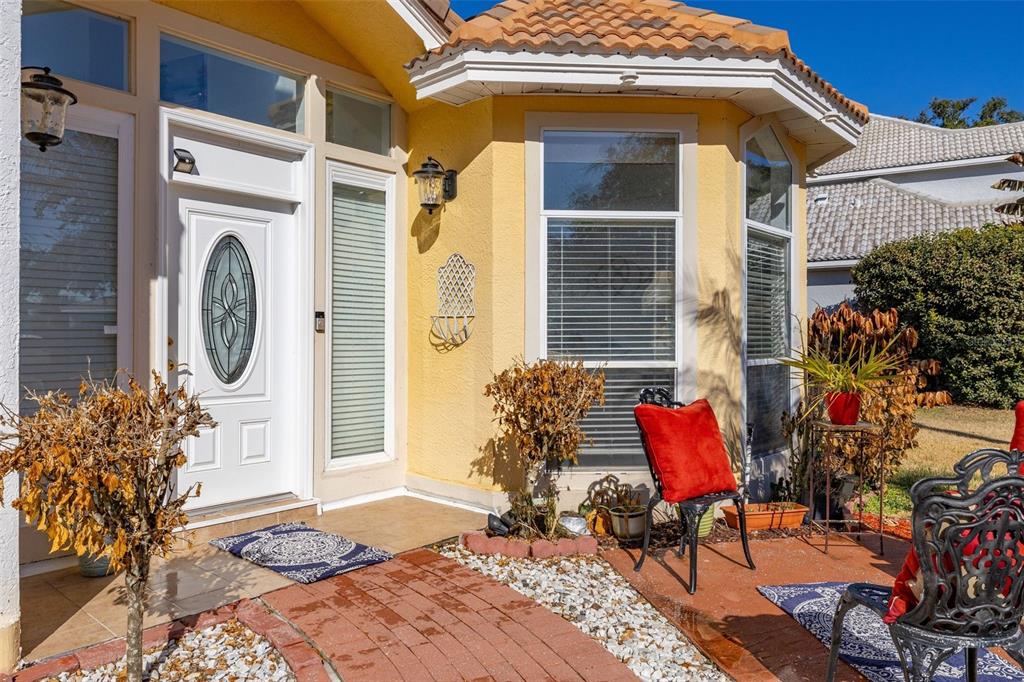 The exterior of a yellow house features a white front door and a brick walkway — 2747 KISSIMMEE BAY CIRCLE, KISSIMMEE, FL